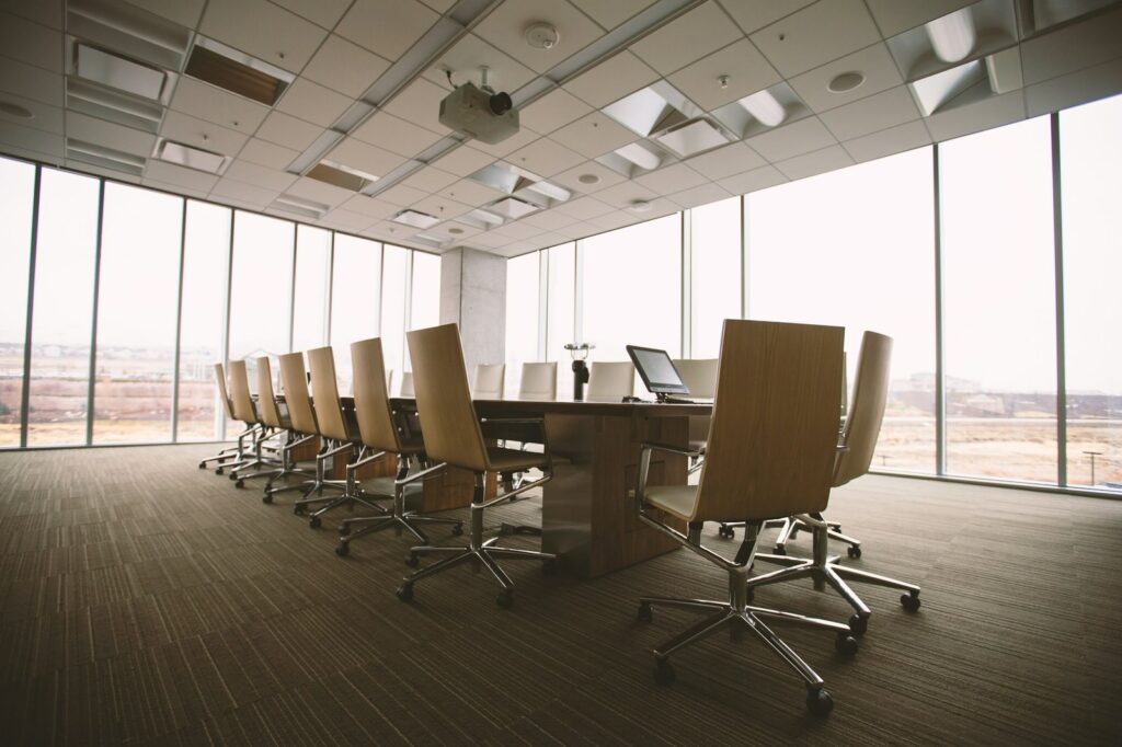 Boardroom with a long table and chairs beside a wall of windows