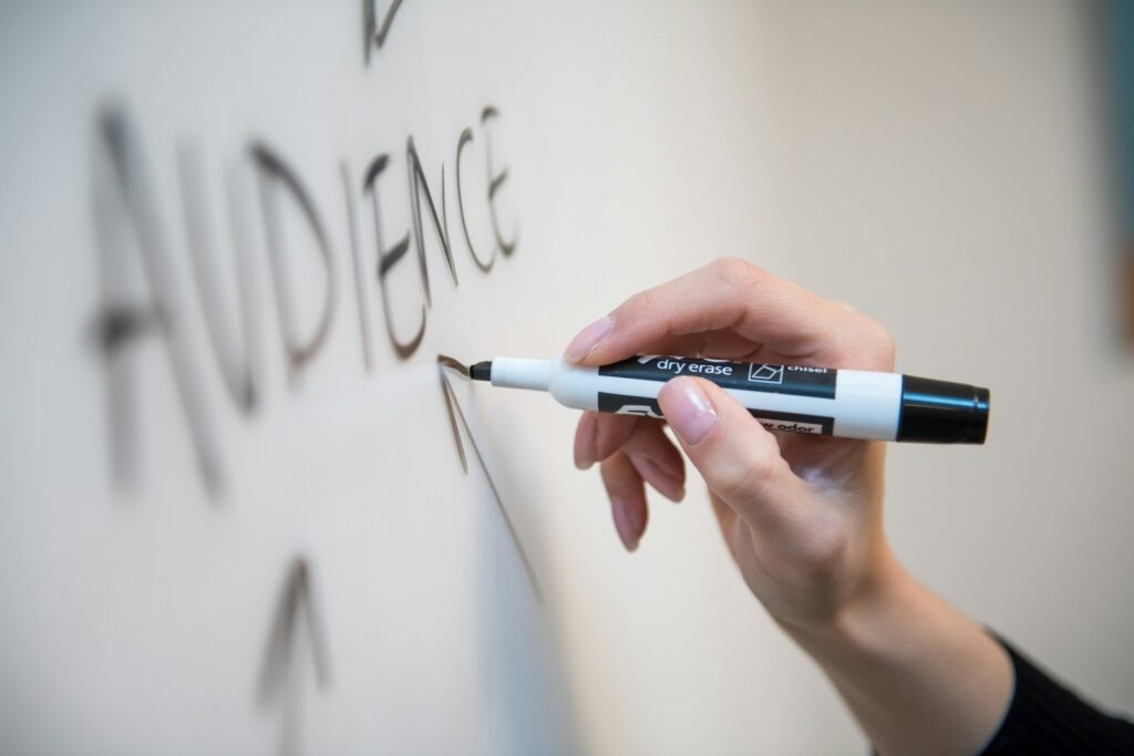 A hand writing on a whiteboard with a marker